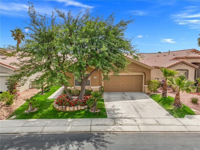 37388 Medjool, Palm Desert, CA 92211 - obstructed view of property with a garage, stucco siding, driveway, a tiled roof, and a front yard