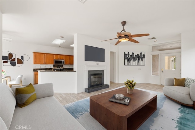 37388 Medjool, Palm Desert, CA 92211 - living room featuring a ceiling fan, light wood finished floors, and a glass covered fireplace