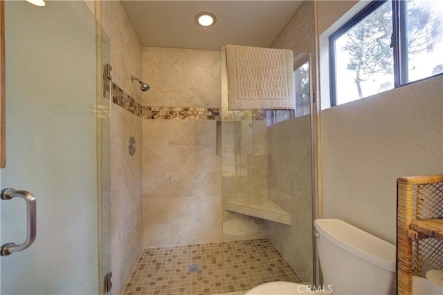 bathroom featuring toilet, recessed lighting, and a stall shower