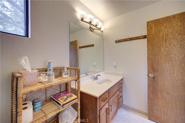 bathroom with vanity, a textured wall, and tile patterned floors