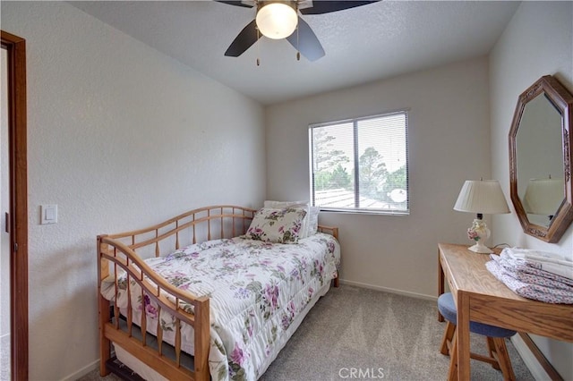 carpeted bedroom featuring baseboards and a ceiling fan