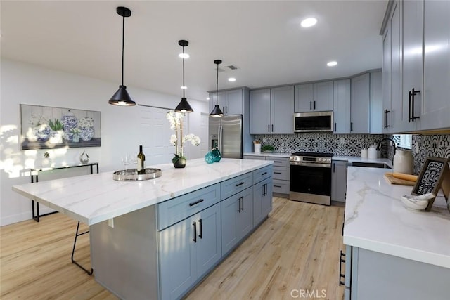 1402 E Luray St, Long Beach, CA 90807 - kitchen featuring light wood-type flooring, appliances with stainless steel finishes, backsplash, and gray cabinetry