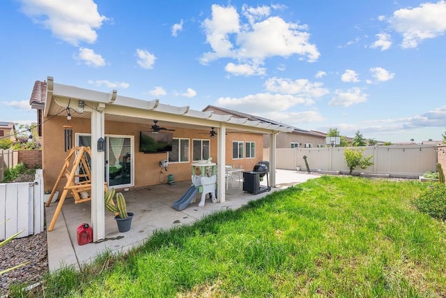 back of property featuring ceiling fan, a lawn, a fenced backyard, a patio, and stucco siding