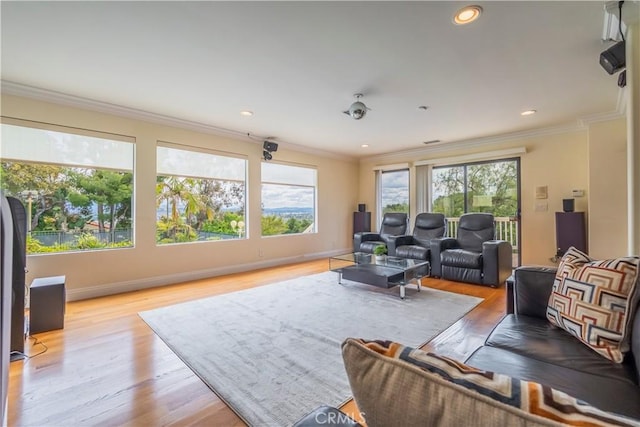 living area featuring crown molding, plenty of natural light, light wood-style floors, and recessed lighting