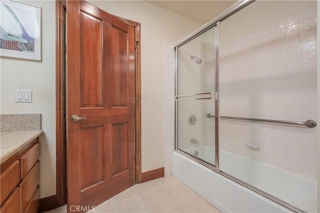 bathroom featuring bath / shower combo with glass door, tile patterned flooring, and vanity