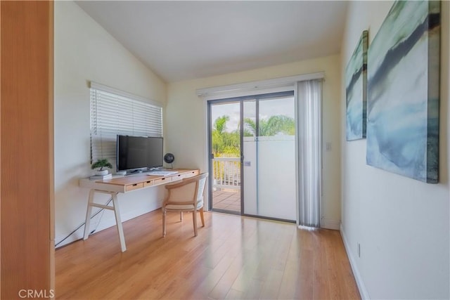 home office with light wood-type flooring, baseboards, and lofted ceiling