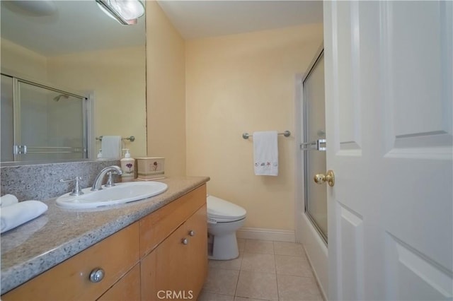 full bath with vanity, toilet, shower / bath combination with glass door, baseboards, and tile patterned floors