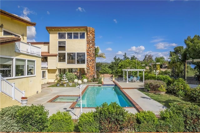 back of house with a fenced in pool, stucco siding, a pergola, and a patio