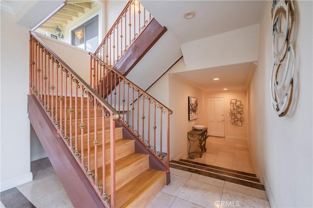 staircase featuring baseboards, tile patterned floors, and recessed lighting