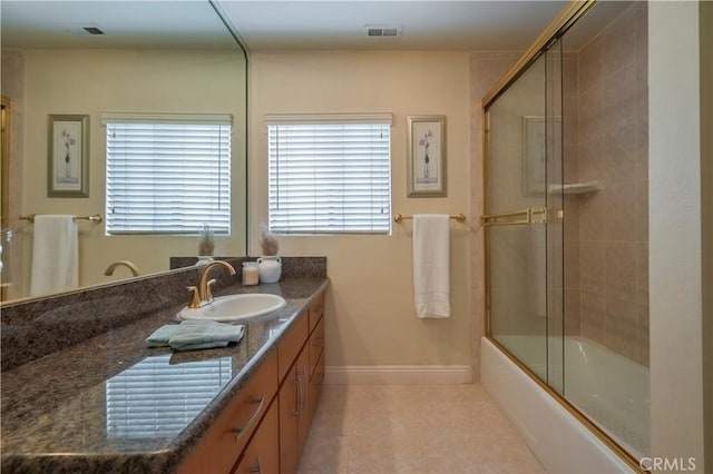 bathroom featuring tile patterned flooring, vanity, enclosed tub / shower combo, baseboards, and visible vents
