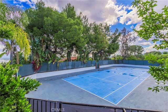 view of tennis court featuring fence