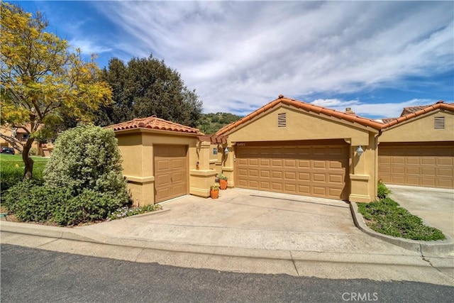 6405 Fiddleneck Ln, Avila Beach, CA 93424 - mediterranean / spanish home with stucco siding, driveway, a tiled roof, and an attached garage