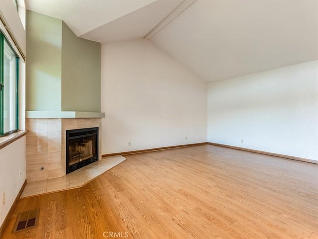 6405 Fiddleneck Ln, Avila Beach, CA 93424 - unfurnished living room featuring a tile fireplace, lofted ceiling, wood finished floors, and baseboards