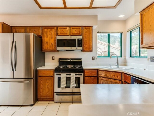6405 Fiddleneck Ln, Avila Beach, CA 93424 - kitchen with appliances with stainless steel finishes, a sink, brown cabinets, light countertops, and light tile patterned flooring