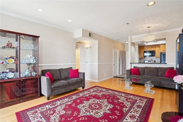 living room featuring light wood-type flooring, recessed lighting, and visible vents