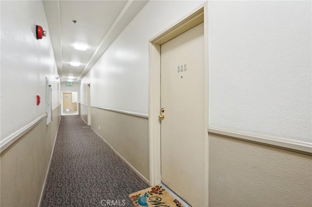hallway featuring carpet floors and baseboards