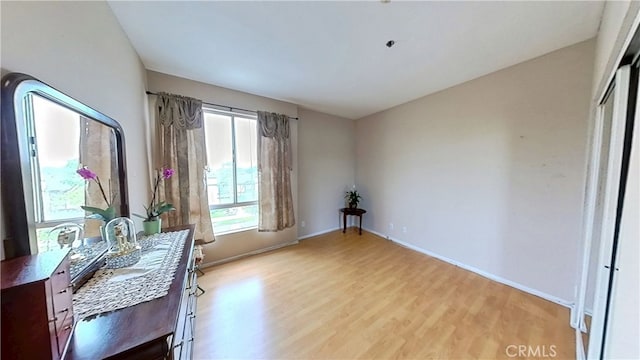 office area with baseboards and light wood finished floors