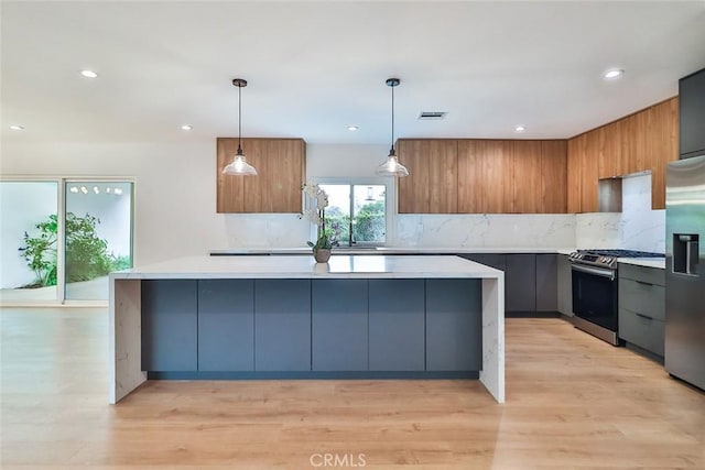 kitchen with visible vents, modern cabinets, a spacious island, light countertops, and stainless steel appliances