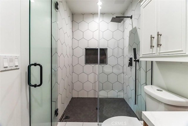 bathroom featuring vanity, toilet, and a stall shower