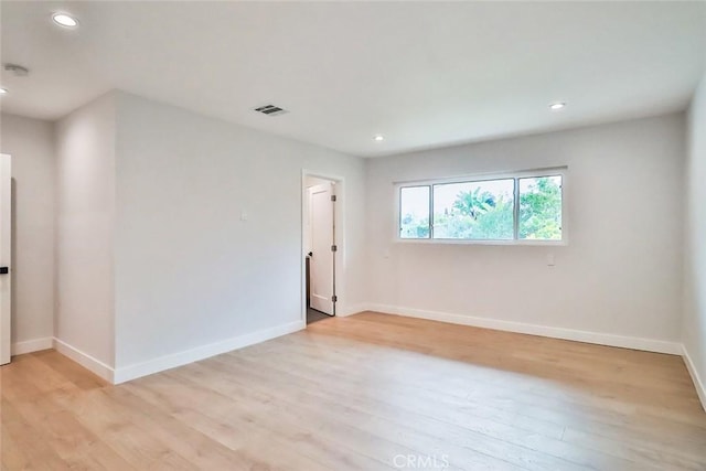 empty room featuring recessed lighting, baseboards, light wood finished floors, and visible vents
