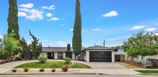 ranch-style house with a garage, fence, decorative driveway, stucco siding, and a chimney