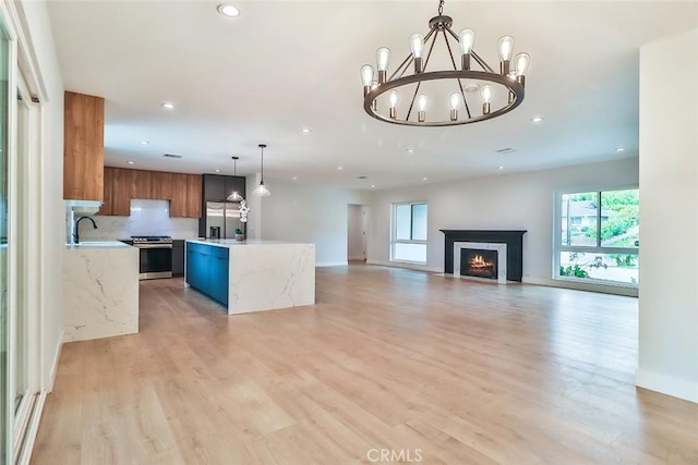 kitchen with brown cabinets, stainless steel appliances, recessed lighting, and light wood-style flooring