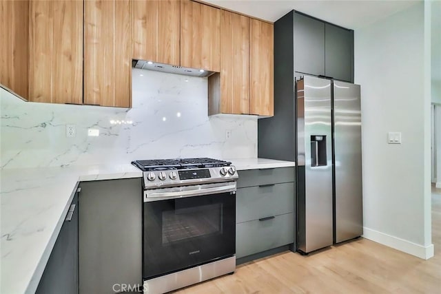 kitchen featuring under cabinet range hood, gray cabinetry, appliances with stainless steel finishes, and modern cabinets