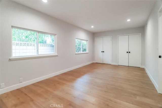unfurnished bedroom with recessed lighting, multiple closets, and baseboards