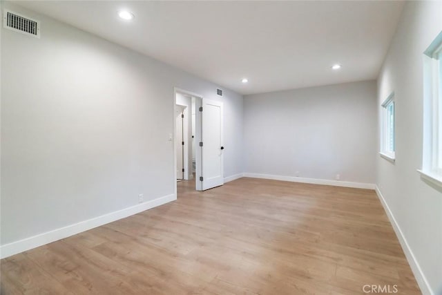 empty room with light wood finished floors, recessed lighting, and visible vents