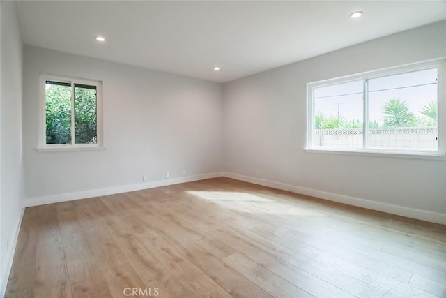 spare room featuring light wood-style floors, baseboards, and recessed lighting