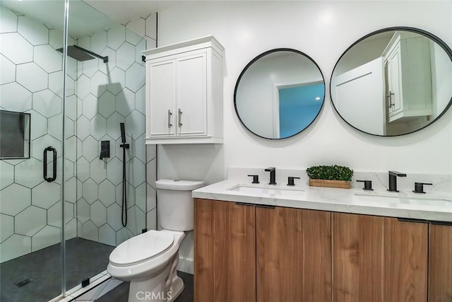 bathroom featuring double vanity, toilet, a shower stall, and a sink