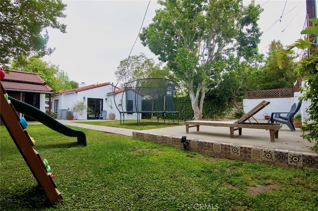 surrounding community featuring a yard, a playground, a patio, and a trampoline