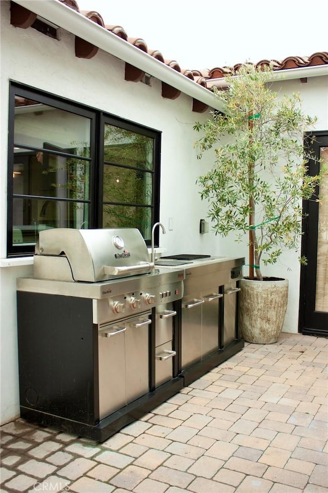 view of patio with grilling area, a sink, and area for grilling
