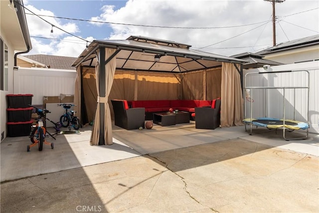 view of patio featuring a fenced backyard, a gazebo, and an outdoor living space