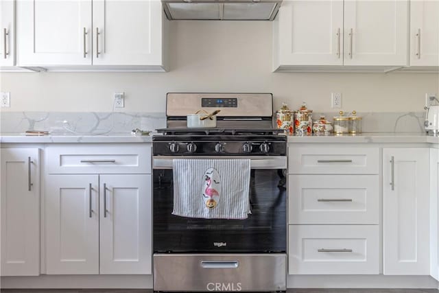 kitchen with range hood, stainless steel gas stove, and white cabinetry