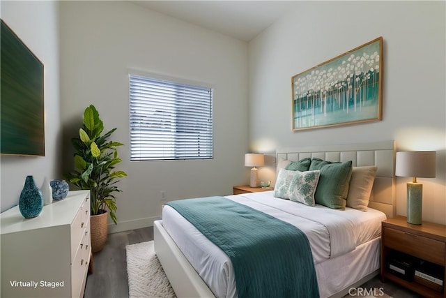 bedroom with baseboards and wood finished floors