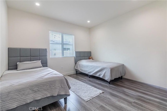 bedroom with recessed lighting, baseboards, and wood finished floors