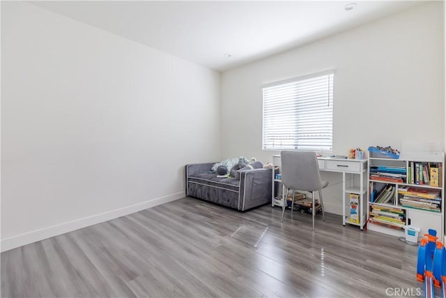 home office with baseboards and wood finished floors