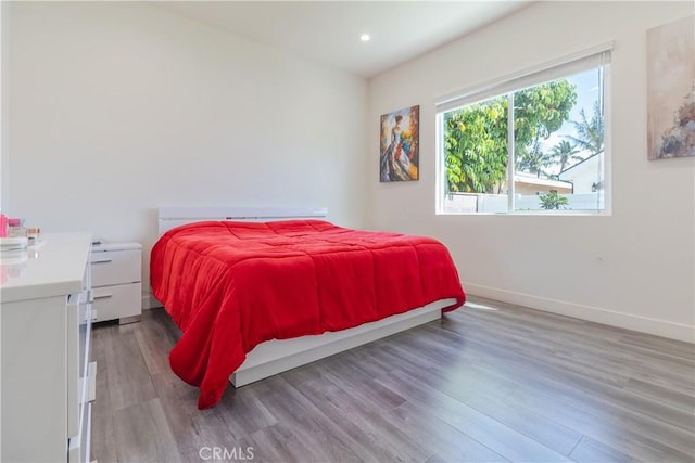 bedroom with baseboards, recessed lighting, and wood finished floors