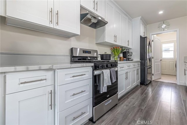 kitchen with appliances with stainless steel finishes, light countertops, white cabinetry, under cabinet range hood, and dark wood-style floors
