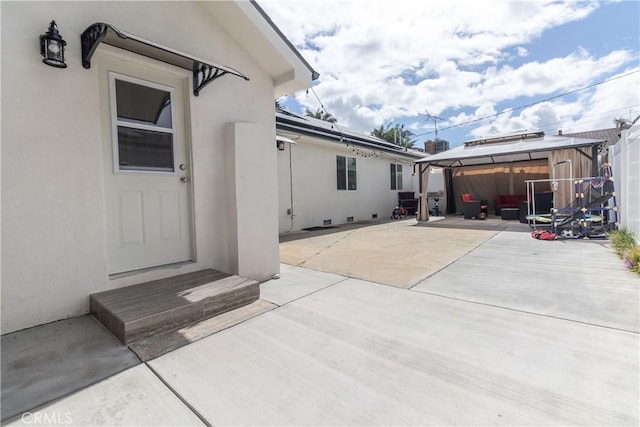 doorway to property with a patio and stucco siding