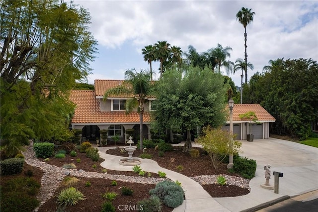 11080 Kayjay St, Riverside, CA 92503 - mediterranean / spanish-style home featuring a tiled roof, driveway, stucco siding, and an attached garage