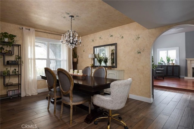 11080 Kayjay St, Riverside, CA 92503 - dining space featuring arched walkways, baseboards, a chandelier, and dark wood-type flooring