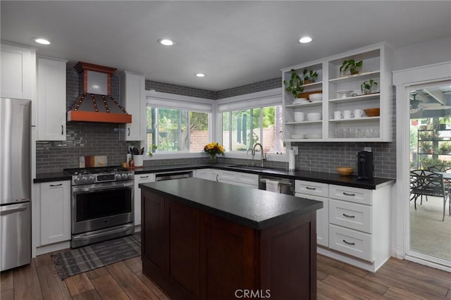 11080 Kayjay St, Riverside, CA 92503 - kitchen with appliances with stainless steel finishes, wall chimney range hood, dark countertops, open shelves, and recessed lighting