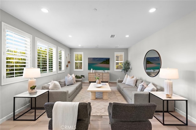living area featuring light wood-style floors, baseboards, recessed lighting, and visible vents