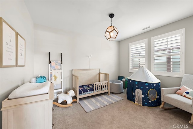 carpeted bedroom with a nursery area and visible vents