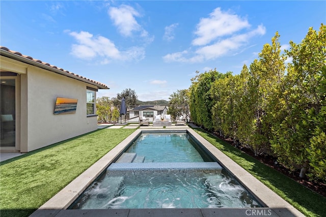 pool with a yard and an in ground hot tub