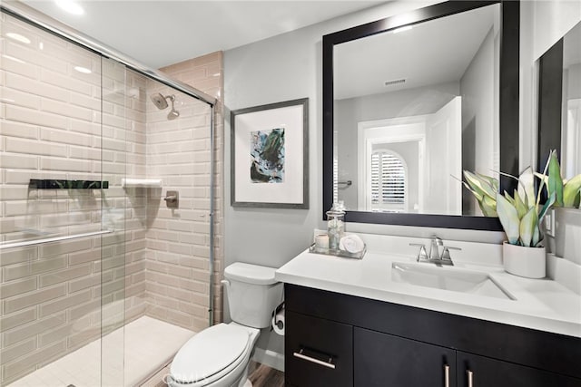 full bath featuring toilet, a shower stall, and vanity