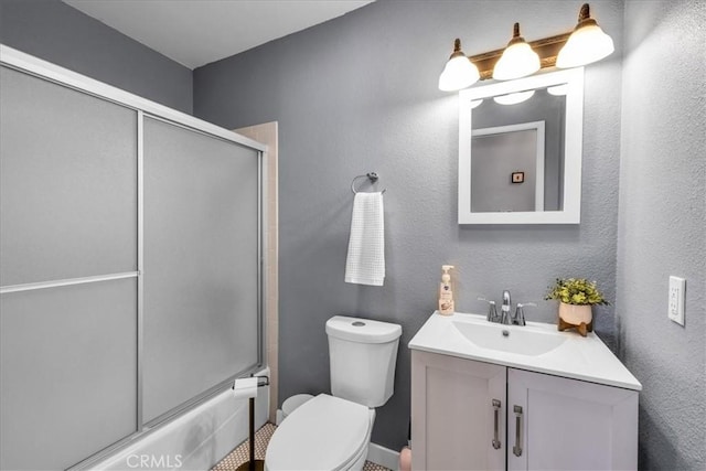 bathroom featuring vanity, toilet, and shower / bath combination with glass door