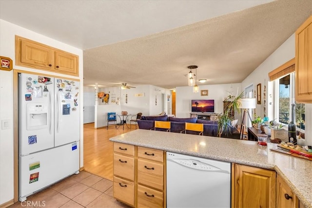 kitchen with a textured ceiling, light tile patterned floors, a peninsula, open floor plan, and white appliances